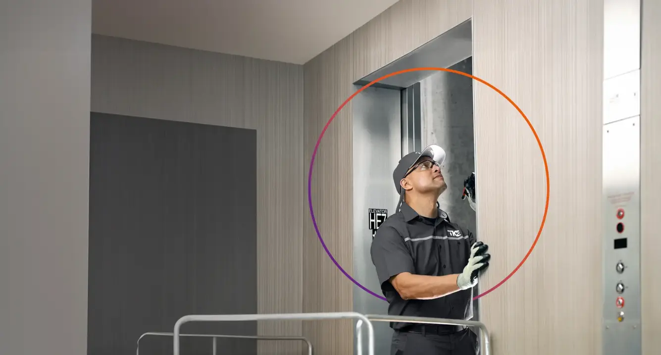 Technicians in safety gear are repairing an elevator