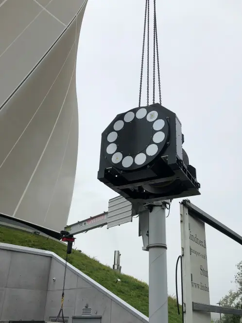 Maschine aufgehangen am Seil am Kran beim Ausladen aus dem LKW