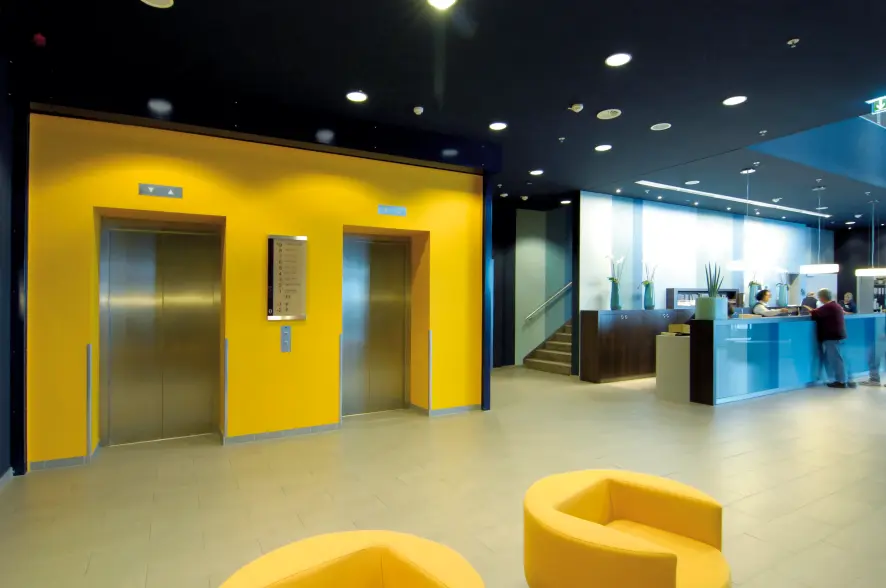 An elevator lobby with yellow accent walls.