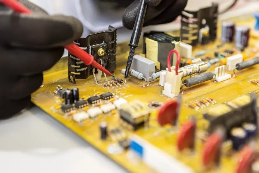 A closeup of an engineer working on a computer board.