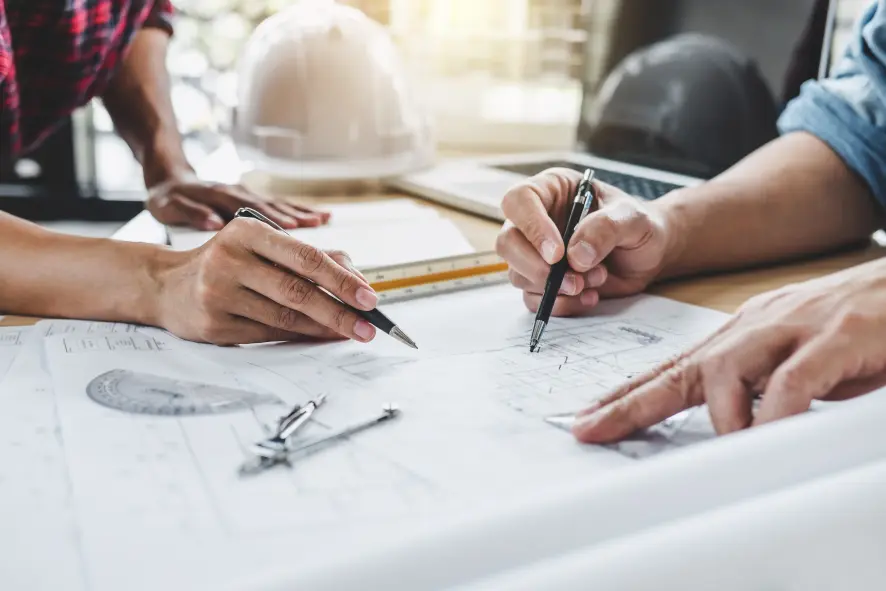 A group of architects mark up a building plan.