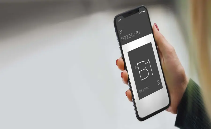 
A woman uses the AGILE Mobile app to summon an elevator using her mobile phone.
