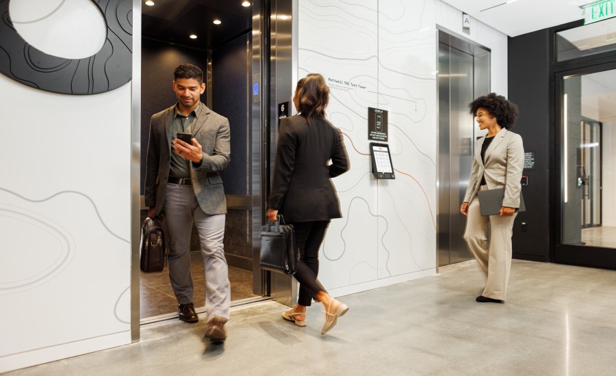 A group of businesspeople enter and exit a TK Elevator high-rise elevator.