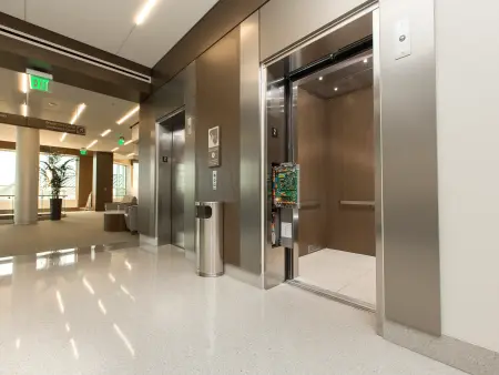 A machine room-less elevator with an open control panel outside its doors.