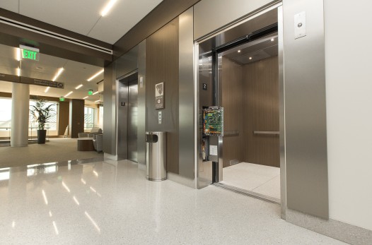 A machine room-less elevator with an open control panel outside its doors.